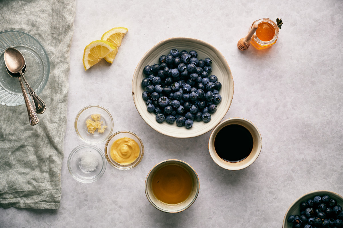 Ingredients for Blueberry Vinaigrette laid out on a white counter.